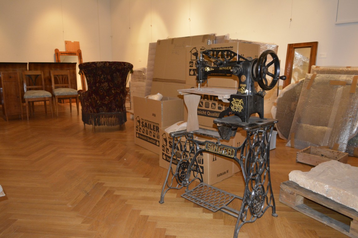 In einem Raum stehen Möbelstücke aus der ehemaligen Ausstellung, vorbereitet für den Transport.