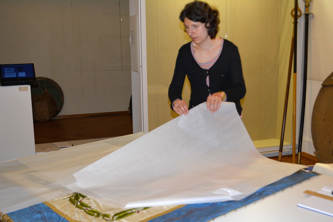 Laura Klama verpackt Textilien in Seidenpapier.