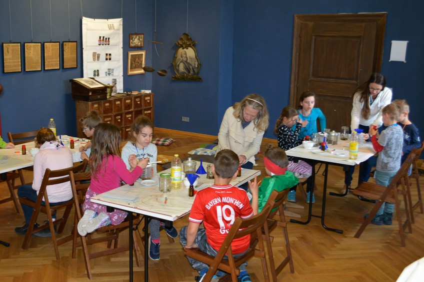 Schulklasse im Museumsraum beim Mischen von Fenchelöl