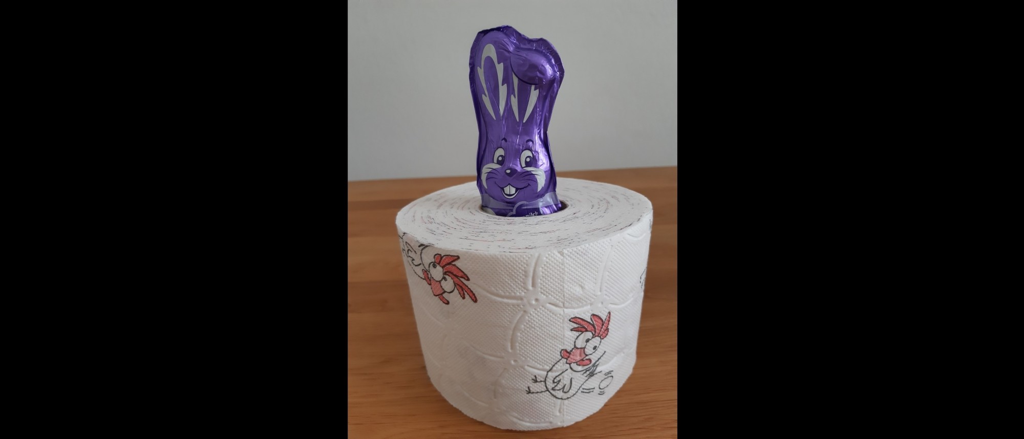 Ein lila Milka-Schokohase in einer Rolle Toilettenpapier.
