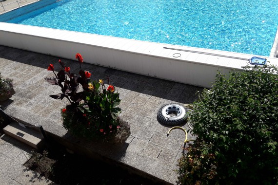 Blick auf das Wellenbecken, davor ein aufblasbarer Schwimmring zwischen Pflanzentrögen