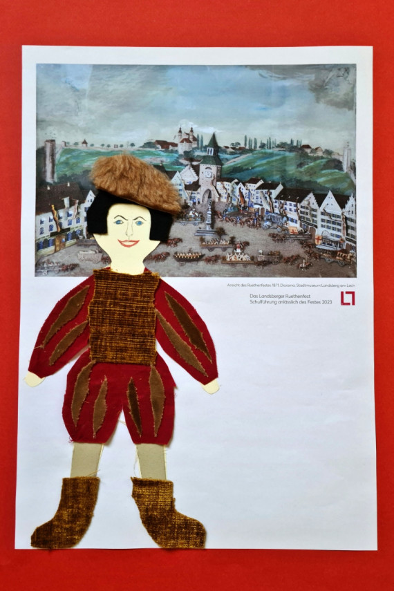 Bastelarbeit aus Papier und Stoffresten, die eine Figur des Ruethenfests in historisch anmutendem Kostüm zeigt. Dahinter die Darstellung eines Ruethenfestumzugs im Scherenschnitt.