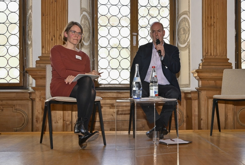 Eva Oberloskamp und Benjamin Carter Hett sitzen auf der Bühne.