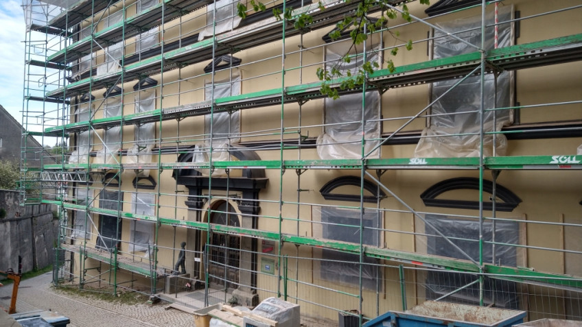 Seite des Museumsgebäudes mit Eingang hinter Baugerüst, Folien vor den Fenstern