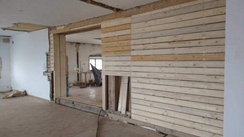 Durchgang in der Wand und frische Holzlatten