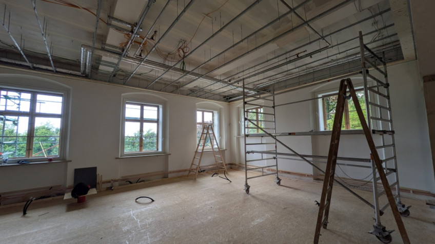 Haltevorrichtung für Deckenabhängung, im Raum stehen Leitern und ein Gerüst.