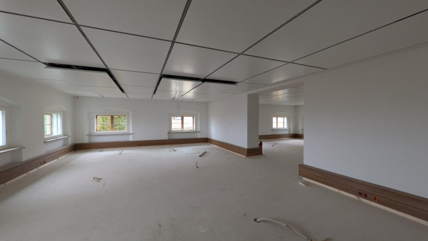 Großer Raum mit weißen Wänden und weißen Deckenpaneelen.