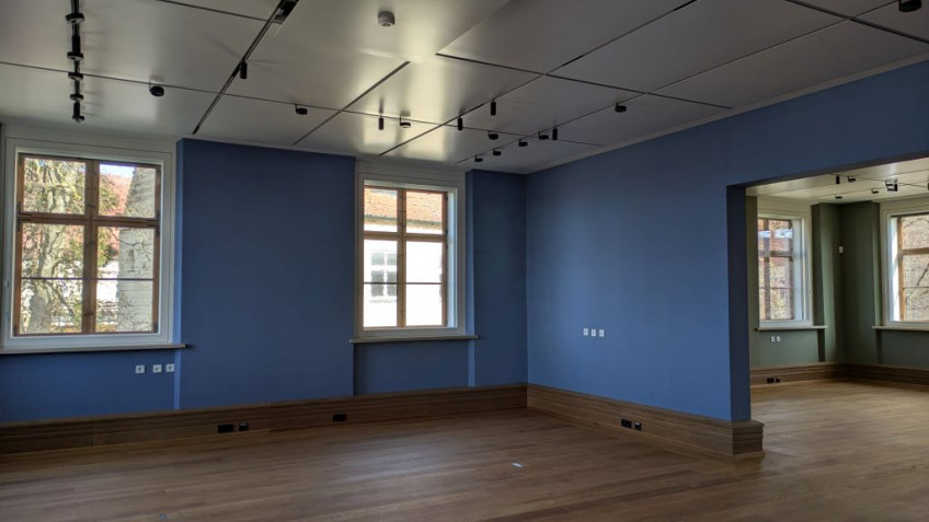 Blick aus einem blau gestrichenen Raum in einen Raum mit gr&uuml;nen W&auml;nden.